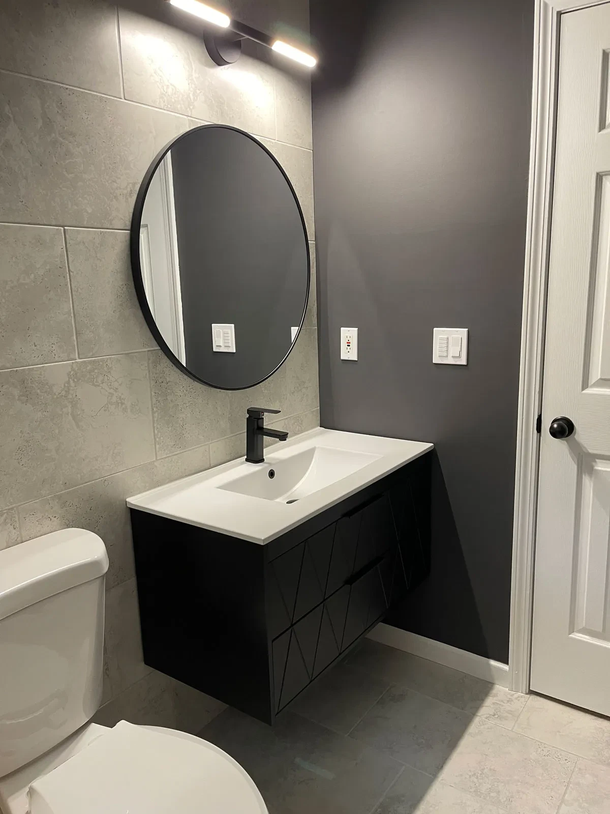 Modern bathroom with grey walls and circular mirror